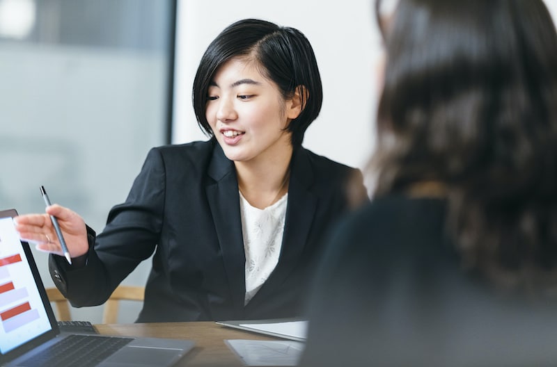 パソコンを使って顧客に説明する営業の女性の様子